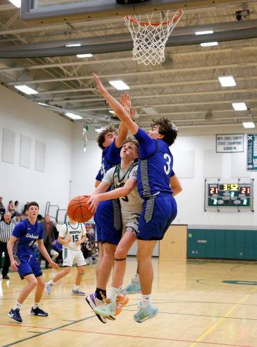 Greenfield’s Grayson Thomas (5) gets wedged on the way to the hoop by Wahconah defenders Sam McLaughlin (24), left, and Aidan Hagmaier (3) in the second quarter Saturday night in Greenfield.