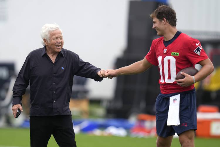 New England Patriots quarterback Drake Maye (10) raps knuckles with team owner Robert Kraft during an NFL football training camp, Thursday, July 25, 2024, in Foxborough, Mass. (AP Photo/Charles Krupa)