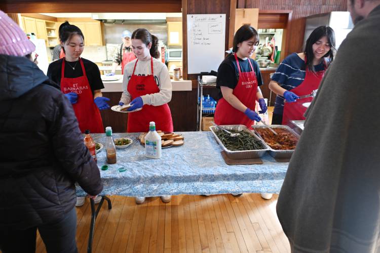 Deerfield Academy students Ellie Nam, Amelia Dickson, Aeris Chang and Vivian Gonzalez serve Second Helpings, a community meal, at the Episcopal Church of Saints James and Andrew in Greenfield.