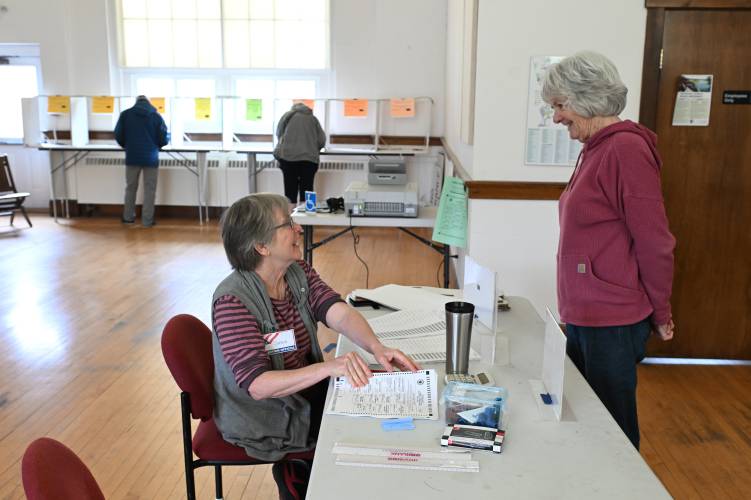 Election worker Susie Secco checks in resident Jan Herlihy to vote at Northfield Town Hall on Tuesday.