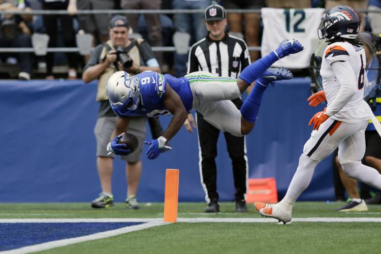 Seattle Seahawks running back Kenneth Walker III (9) leaps into the end zone for a touchdown during the second half of an NFL football game against the Denver Broncos, Sunday, Sept. 8, 2024, in Seattle. (AP Photo/John Froschauer)