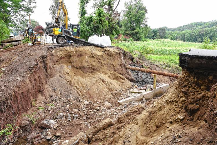 Construction crews work to rebuild Lower Road in Deerfield that was cut in half by a small stream during a July deluge, sweeping away a car. The pipe in the photo, pictured in August, is a water supply.