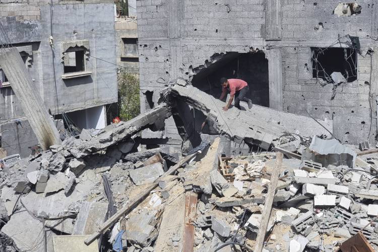 Palestinians look through the rubble after an Israeli airstrike in Rafah, Gaza Strip, on Monday.