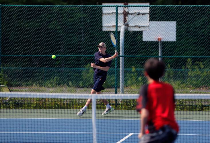 Frontier’s Oliver Brown volleys against Derek and Devan Ye of PVCICS while competing in their No. 1 doubles match during the Western Mass. Class C boys tennis semifinal match last year at Hampshire College.