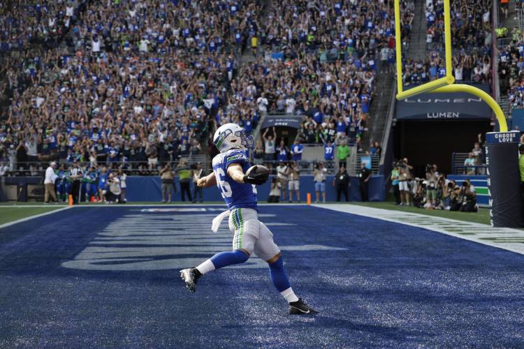 Seattle Seahawks running back Zach Charbonnet (26) scores a touchdown during the second half of an NFL football game against the Denver Broncos, Sunday, Sept. 8, 2024, in Seattle. (AP Photo/John Froschauer)