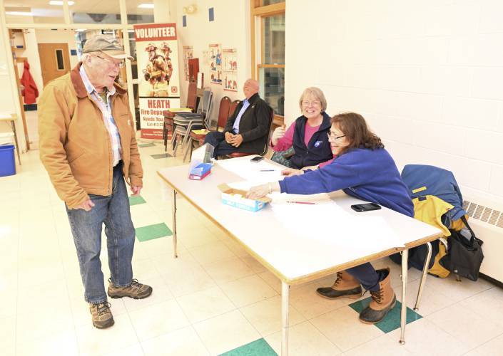 Budge Litchfield is checked in to vote by Constable Steve Thane, his wife Registrar Nancy Thane and election worker Cathy Tallen at the Jacobs Road Municipal Center on Friday.