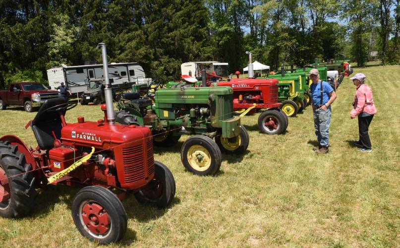 A couple checks out a row of tractors at the 2024 Bernardstson Gas Engine, Flea Market and Craft Fair. The 49th annual event returns this weekend.