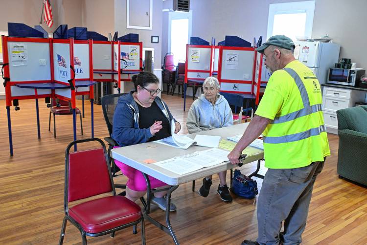 Montague election workers Annie Levine and Kathy Chevalier check in voter Charles Emery at the Gill-Montague Senior Center in Turners Falls on Tuesday. Montague election workers Annie Levine and Kathy Chevalier check in voter Charles Emery at the Gill-Montague Senior Center in Turners Falls on Tuesday.