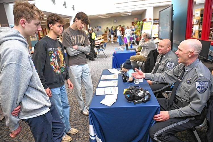 Frontier Regional School seniors Oliver Brown, Charlie Dennis and Tegan Dexter talk with Capt. Robert Haughey and Capt. Jason Collins of the Franklin County Sheriff’s Department during the Frontier Career Fair in the Media Center last week.