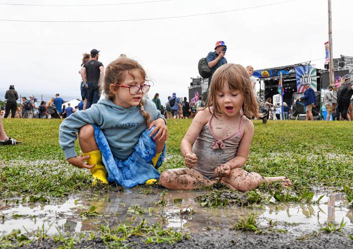 Joslyn Peters, 5, and Georgiana Faulk, 3, play in a mud puddle on Saturday at the Green River Festival at the Franklin County Fairgrounds.