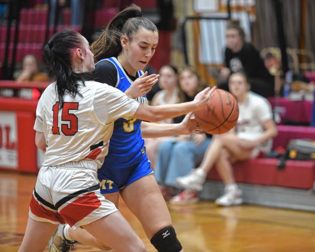 Athol's Maddie Hermes, left, tries to knock the ball away from Mohawk Trail's Valerie Bzomowski on Friday at Mallet Gymnasium in Athol. 