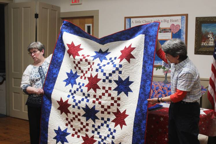 North Orange Grange Secretary Nancy Blackmer, left, and Treasurer Pam Gale hold up a Quilt of Valor destined for veteran Paul Lyman at a ceremony at the Community Church of North Orange and Tully on Tuesday. Lyman was unable to attend the ceremony.