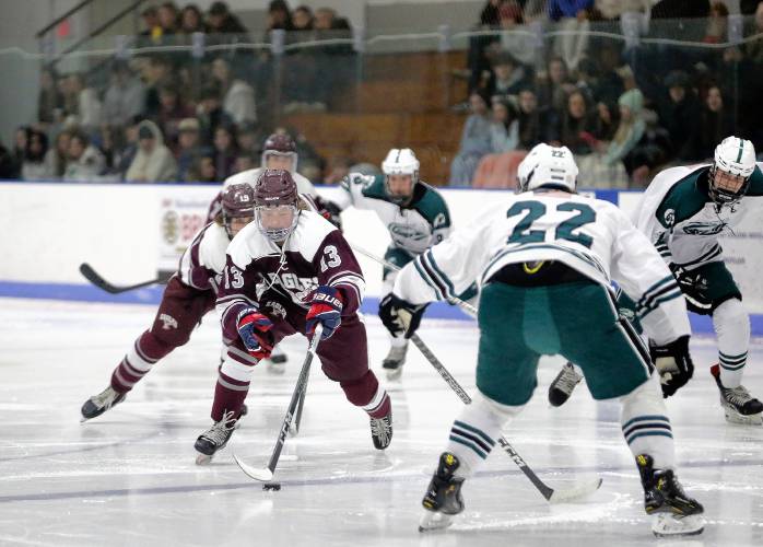 Easthampton’s Grayson Prevey-Catrambone (13) charges with the puck toward Greenfield defender Derek Wissman (22) in the second period Saturday night at Collins-Moylan Arena in Greenfield.