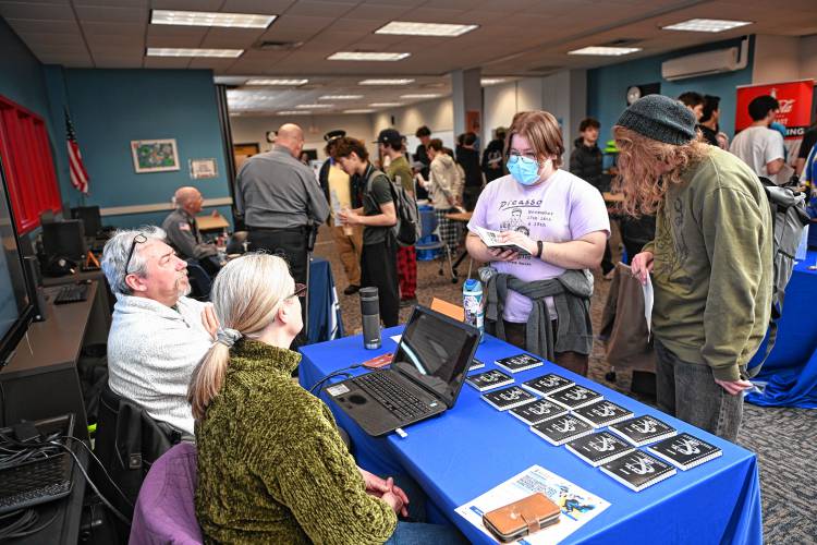 Mik Muller and Donna Dusell of Montague Webworks talk with students Leo Vickery and Magnus Harrison during the Frontier Career Fair in the Media Center last week.