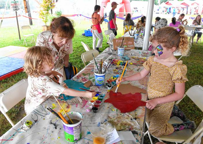 Gillian Ryan of Monterey, helps Felix Salbey, 4, of Brooklyn, NY, and Eleanor McCarthey, 6, of Newport RI, create art for the art parade in The Art Garden tent on Saturday at the Green River Festival at the Franklin County Fairgrounds.