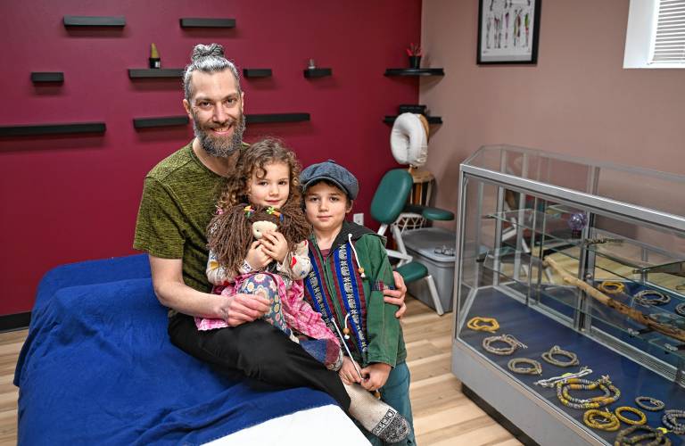 Massage therapist Daniel Rosen in his Greenfield office at 51 Davis St. with his children, Akasha, 4, and Kaya Zohar, 7.