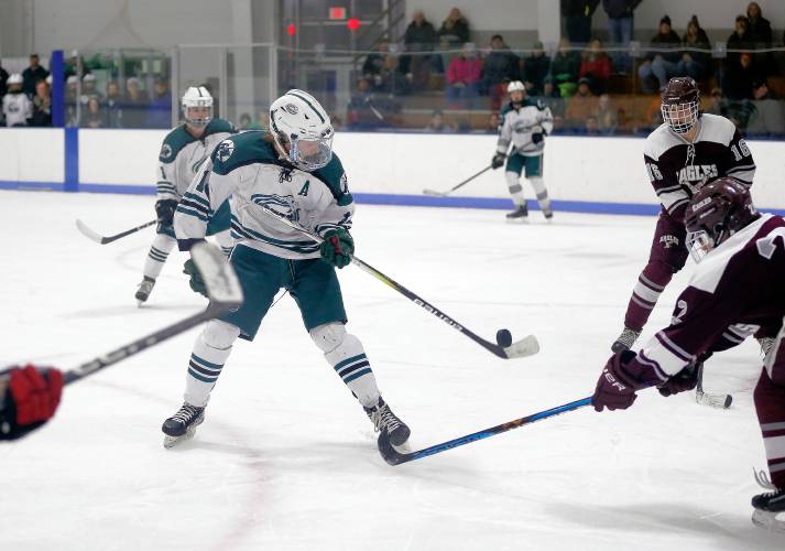 Greenfield’s Matt Garvin (14) fights for a loose puck against Easthampton in the second period Saturday night at Collins-Moylan Arena in Greenfield.