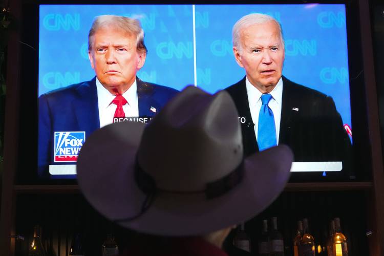 Roger Strassburg, of Scottsdale, Ariz., wears a cowboy hat as he watches the presidential debate between President Joe Biden and Republican presidential candidate former President Donald Trump at a debate watch party Thursday, June 27, 2024, in Scottsdale, Ariz. 