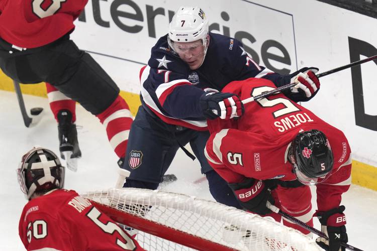 United States' Brady Tkachuk checks Canada's Devon Toews (5) during the first period of the 4 Nations Face-Off championship hockey game, Thursday, Feb. 20, 2025, in Boston. (AP Photo/Charles Krupa)
