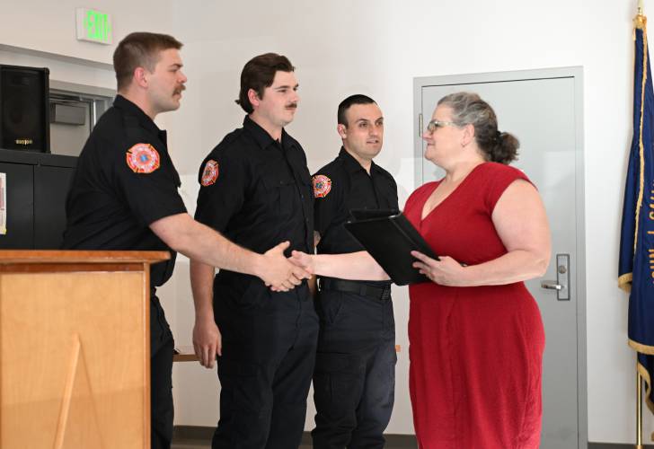 Greenfield City Clerk Kathy Scott congratulates the newest members of the Greenfield Fire Department after swearing them in on Wednesday at the John Zon Community Center. From left are Brian Dew, Matthew Gardner and Chris Allen.