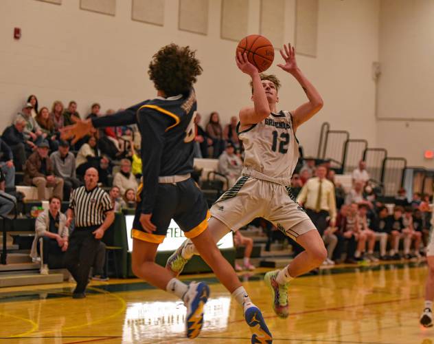 Greenfield’s Caleb Thomas (12) pulls up for a shot against Hopkins Academy during the Green Wave’s Hampshire League South victory at Nichols Gymnasium in Greenfield on Friday night.