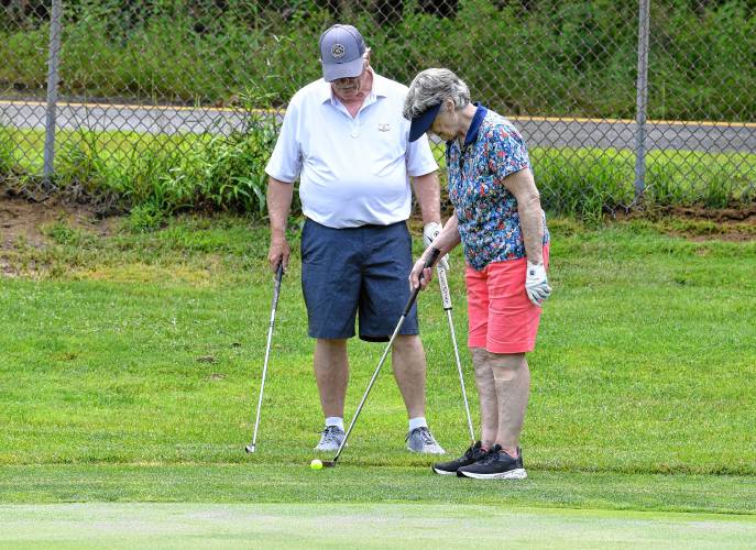 Barry Dow helps partner Margo Worden line up her putt on the first hole at the Country Club of Greenfield during 18-Hole Women’s League play on Tuesday.