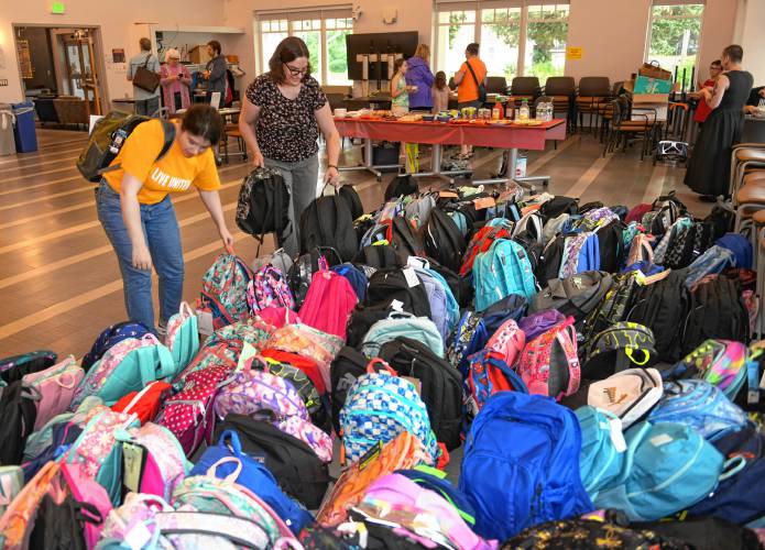 Elsa Kieffer and Jenny Coeur of United Way of the Franklin & Hampshire Region organize backpacks full of school supplies at the John Zon Community Center in Greenfield last week as part of the 20th annual Blooming Backpacks drive organized by Women’s Way, an affinity group of the local United Way.