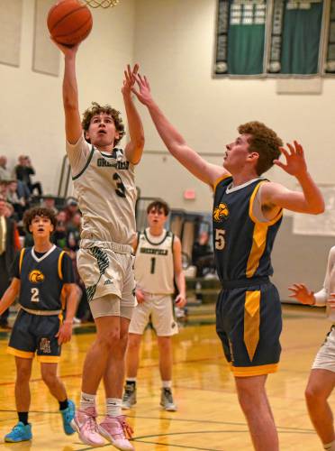 Greenfield’s Oliver Postera (3) puts up a shot over Hopkins Academy’s James Fitzgibbons (15) during the Green Wave’s Hampshire League South victory at Nichols Gymnasium in Greenfield on Friday night.
