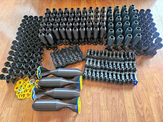 An assortment of 3D-printed tails, droppers, speed loaders and caps recently received by a volunteer distributor in Kyiv, Ukraine. Luke Henrici is using 3D printers at his Ashfield home to make equipment to send to Ukraine to help in the war against Russia.
