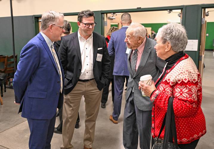 Shawn Palmer and Dan Crowley, publisher and executive editor, respectively, of the Greenfield Recorder, Daily Hampshire Gazette and Athol Daily News, greet Greenfield Recorder Citizen of the Year Russell Deane of Bernardston and friend Drenna Mahaney at the dining commons at Deerfield Academy on Friday morning.