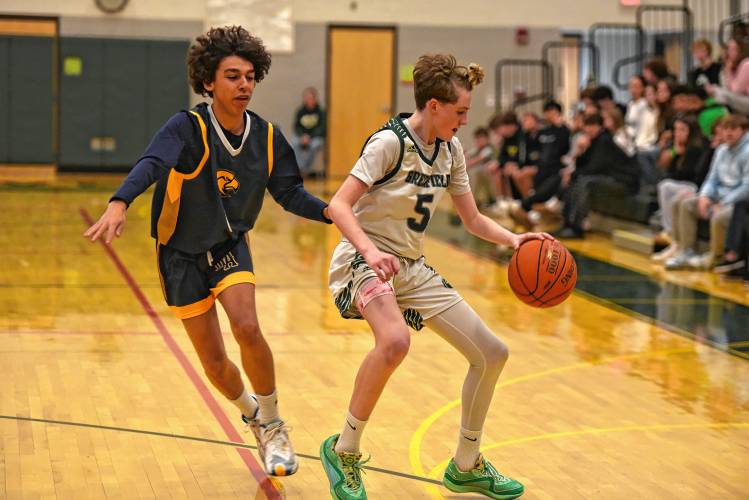 Greenfield’s Grayson Thomas (5), right, dribbles against Hopkins Academy’s Nate Rickles (0) during the Green Wave’s Hampshire League South victory at Nichols Gymnasium in Greenfield on Friday night.