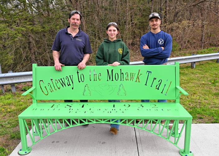 Franklin County Technical School senior Laynie Coates, center, who made this bench in the welding and metal fabrication lab for her capstone project, is flanked by her instructors John Passiglia and Gabe Stafford. 