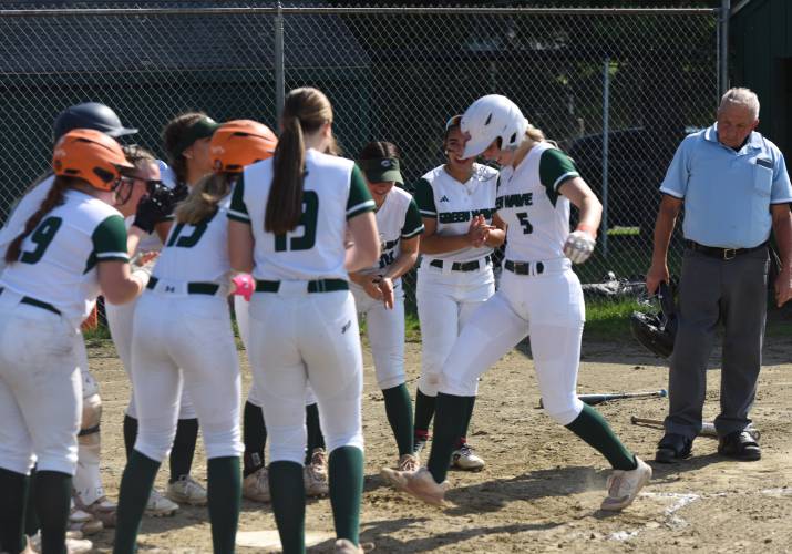 Greenfield’s MacKenzie Paulin stomps on home plate while being greeted by her teammates during the Green Wave’s 5-2 win over Agawam on Friday afternoon at Vets Field in Greenfield.