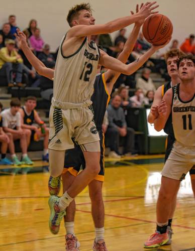 Greenfield’s Caleb Thomas (12) goes to the basket against Hopkins Academy during the Green Wave’s Hampshire League South victory at Nichols Gymnasium in Greenfield on Friday night.
