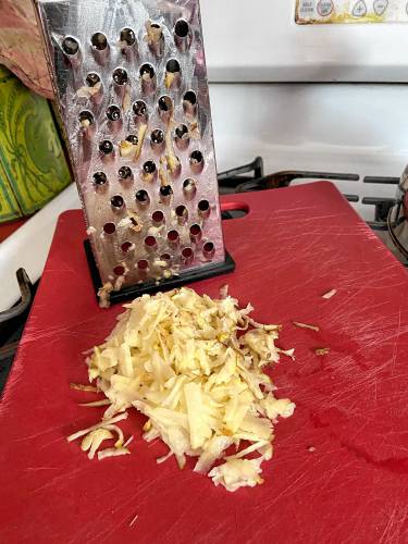 After grating your potatoes, wrap the potato shreds in a dish towel. Carry it to the sink, wring it out, and allow the potato pieces to drain into the sink while you assemble the rest of the ingredients and maybe have a cocktail or two.