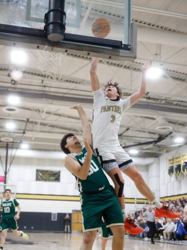 Pioneer’s Kurt Redeker (3) goes in for a layup over Ware defender Noah Perry (50) in the fourth quarter of the MIAA Division 5 quarterfinal Friday night in Northfield.