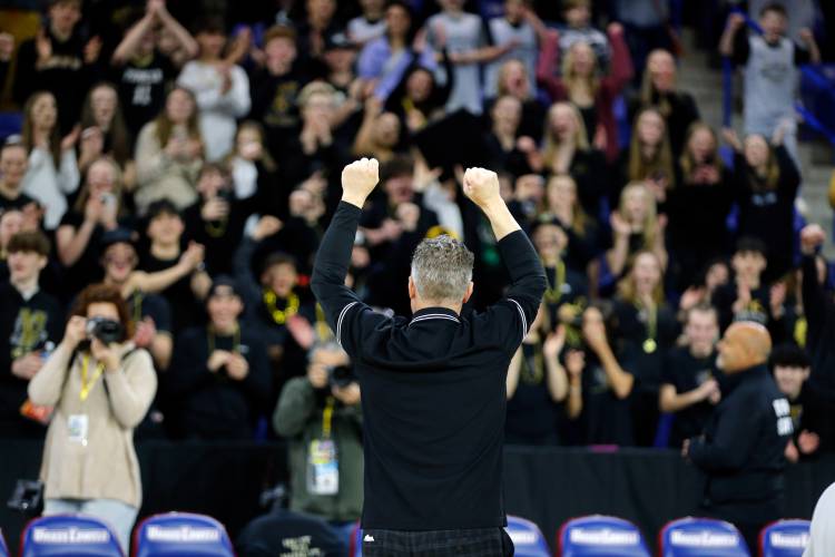 Pioneer head coach Scott Thayer celebrates with fans after their 49-28 win over Hopedale for the MIAA Div. 5 state championship Saturday at the Tsongas Center in Lowell. 