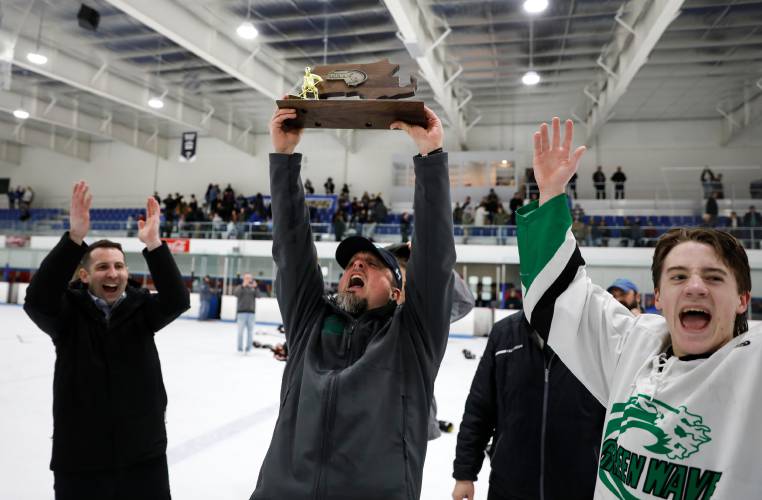 Greenfield coach Adam Bouchard celebrates with the Western Mass. Division 3A trophy at the Olympia Ice Center in West Springfield in 2020.