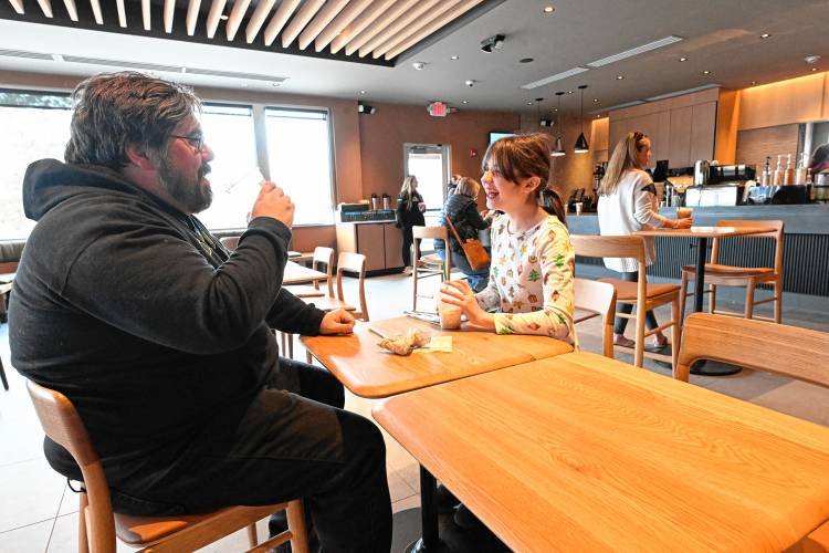 Mark Fitzpatrick and his daughter Emma Fitzpatrick, 11, of Greenfield, enjoy beverages at the newly opened Starbucks on the Mohawk Trail in Greenfield on Thursday.