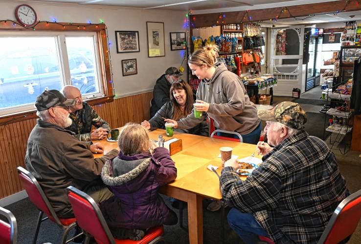 Brooke Flanders, Helen and Robert Baker’s granddaughter, serves coffee to customers at Baker’s Country Store in Conway.