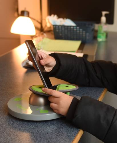 A Greenfield Middle School student turns off and locks a cellphone in a Yondr pouch upon arriving at school in 2023. Putting cellphones in these pouches, which were also implemented at Pioneer Valley Regional School in Northfield,  has resulted in students paying more attention in class and socializing among themselves, Pioneer administrators say.
