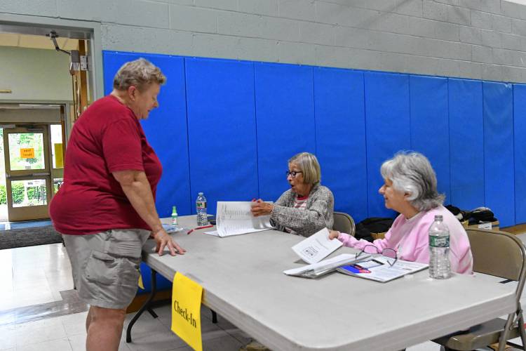 Charlemont resident Mary Malmros is checked in to vote at Hawlemont Regional School on Tuesday by election workers Kathy Hallenbeck and Lydia Canon.