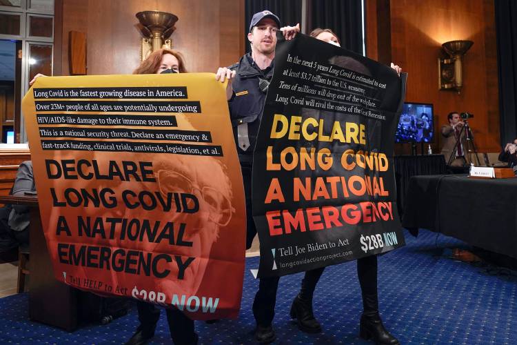 Protestors at a Senate Health, Education, Labor and Pensions hearing to examine addressing long COVID last January on Capitol Hill in Washington.