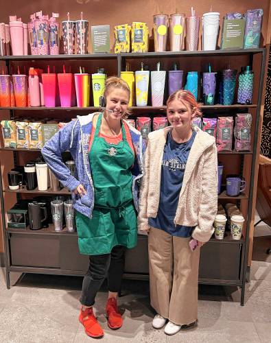 Emma Lanoue, a seventh grader at Pioneer Valley Regional School, at right, was the Greenfield Starbucks’ first customer on Thursday. She is pictured with a Starbucks employee named Casey.
