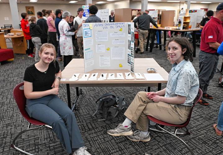 Ralph C. Mahar Regional School students Ella Manson and Florian Gordon-Halpern with their science experiment studying the effects of different liquids on oil-soaked feathers at the school science fair last week.