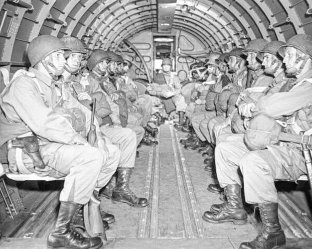 American paratroopers, heavily armed, sit inside a military plane as they soar over the English Channel en route to the Normandy French coast for the Allied D-Day invasion of the German stronghold during World War II, June 6, 1944.