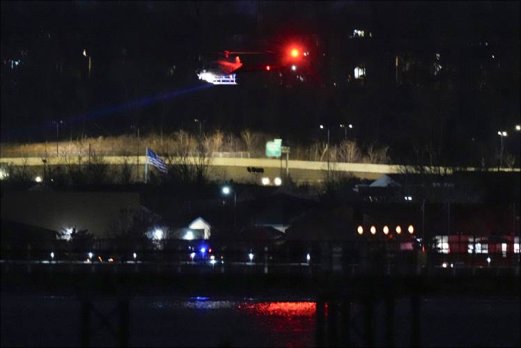 A helicopter uses its searchlight as it flies above the Potomac River near Ronald Reagan Washington National Airport Wednesday, Jan. 29, 2025, in Arlington, Va. (AP Photo/Alex Brandon)