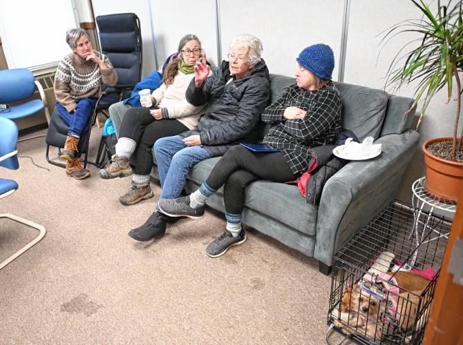 Rowe residents stay warm in Rowe Town Hall while waiting for their power to be restored on Tuesday. From left are Becky Richardson, Susan Gleason, Evie Dandeneau and Loretta Dionne who brought her dogs, Sassy and Lady. 