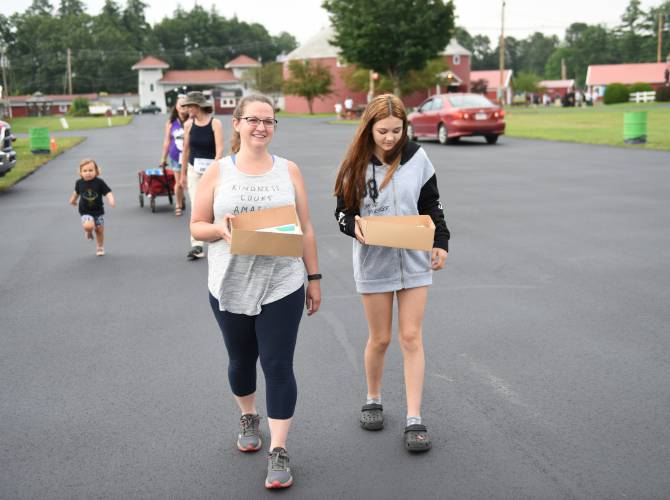 Greenfield resident Kristina Piskorski and her mentee Ellie collect food at stops during the Big Brothers Big Sisters Point 5K fundraiser at the Franklin County Fairgrounds in 2023. The event, which is rodeo-themed this year, returns on Thursday, July 18.