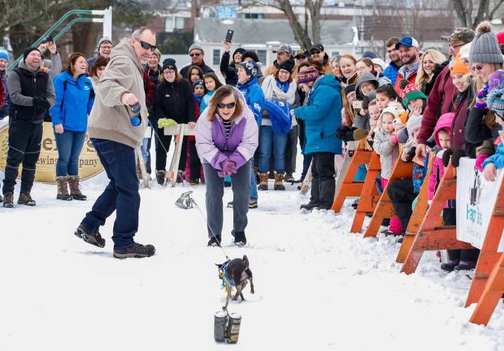 Cathie Llewelyn coaxes her chihuahua, Macho Chewbacca, toward the finish line while competing in the K-9 keg pull during the 2019 Winter Carnival at Beacon Field in Greenfield. The 102nd annual event returns Friday through Sunday.